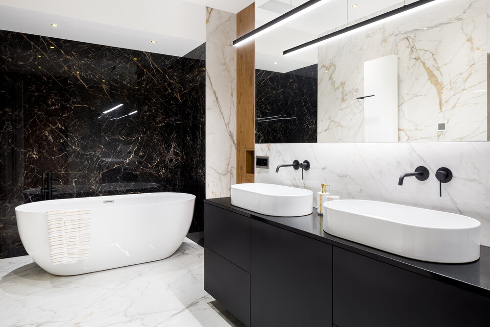 Černá koupelna se zrcadlovou stěnou a mramorovými dlaždicemi
